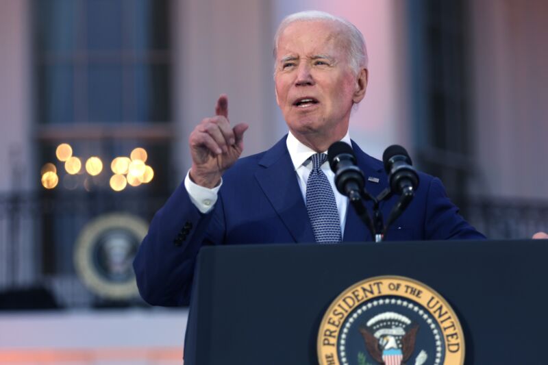 President Joe Biden pointing with his right hand and speaking into microphones at a podium set up outside the White House.